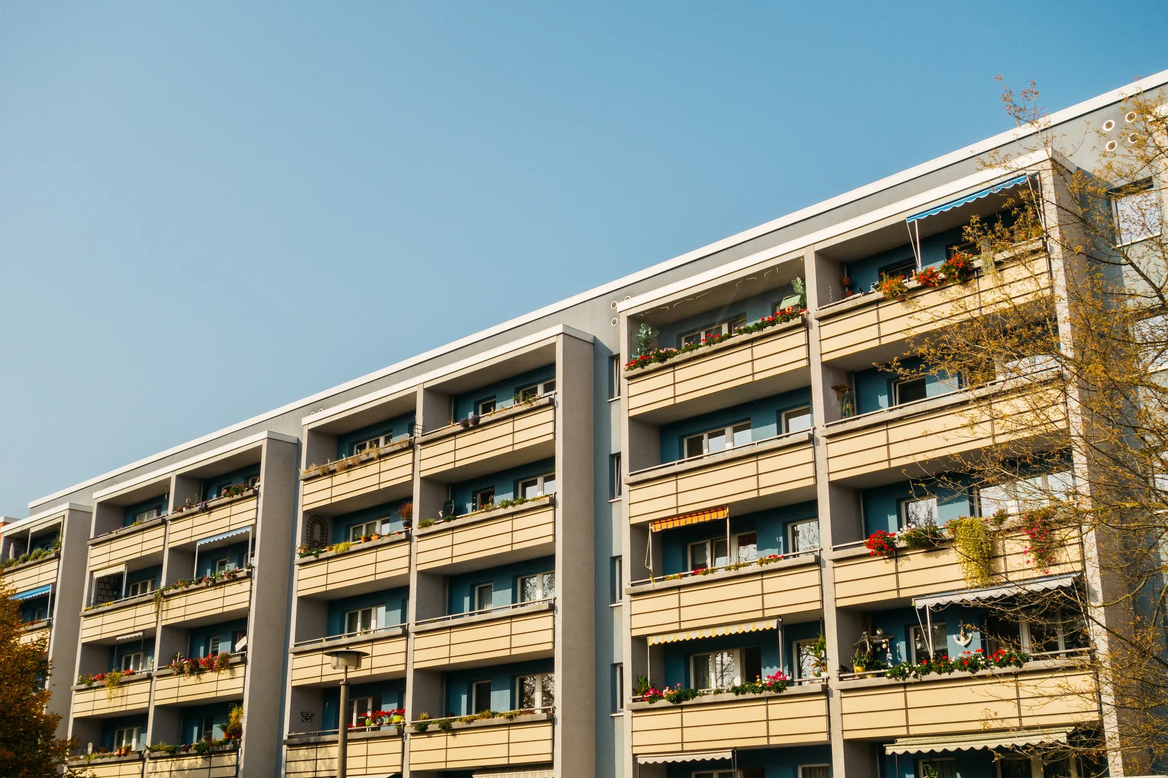 Modernes Wohngebäude mit vielen Balkonen und Blumen