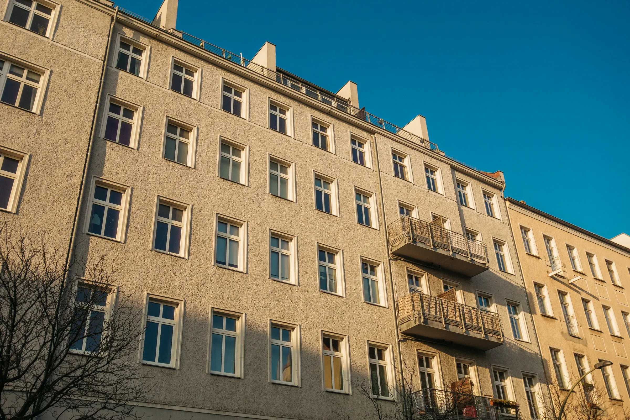 Mehrgeschossiges Wohnhaus mit Balkonen vor blauem Himmel